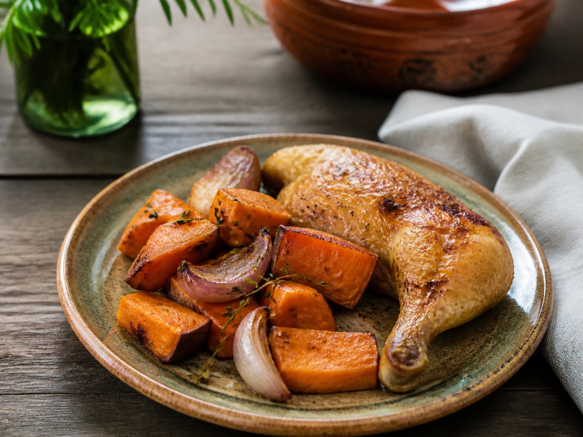 Pollo horneado con camote servido en una porción casera con ingredientes visibles