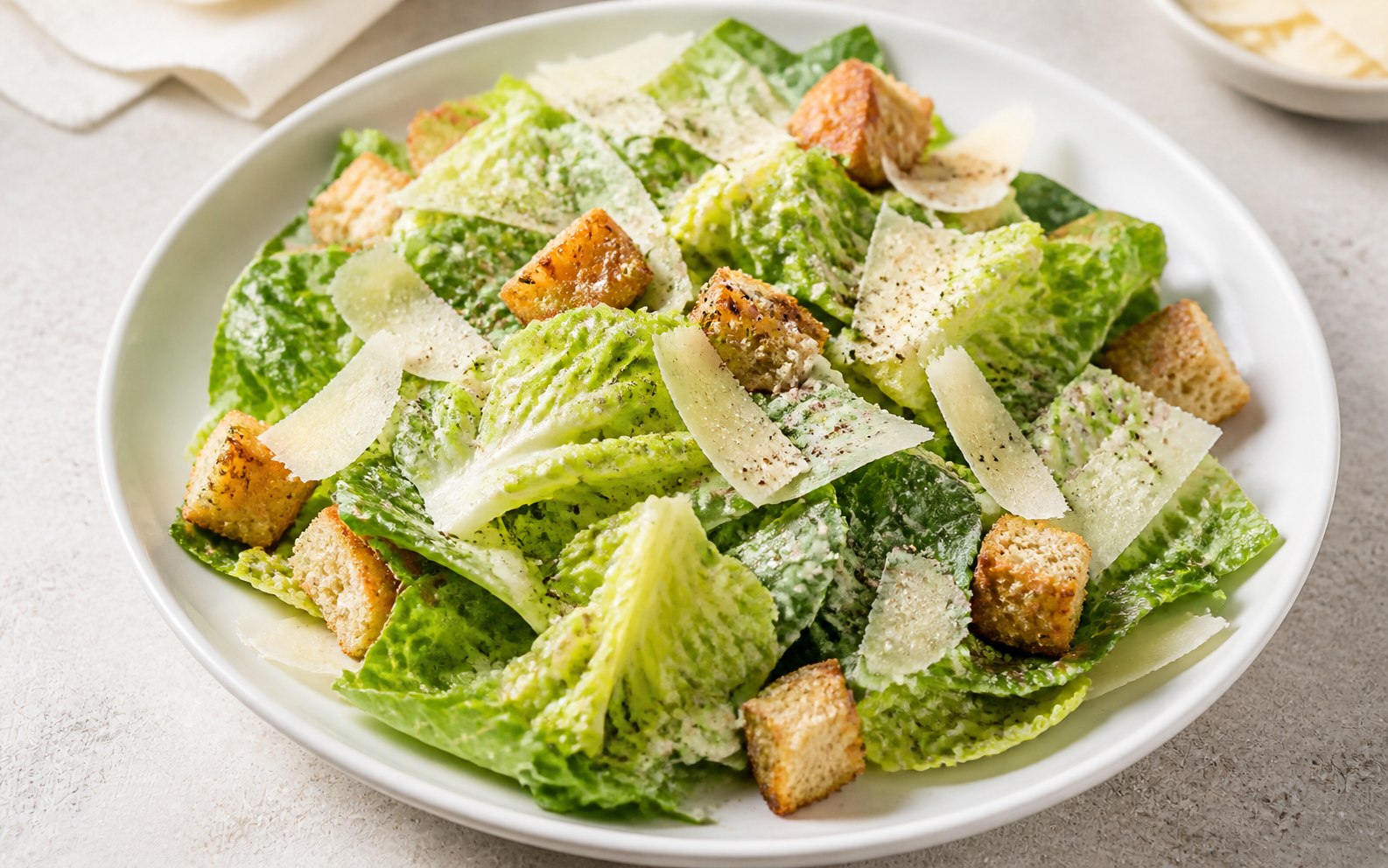 Ensalada Caesar con parmesano en lascas y crutones